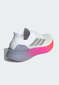 Scarpa da corsa bianca con tomaia testurizzata, suola sfumata grigia e rosa e tre strisce metalliche sul lato. Presenta la scritta "BOOST".