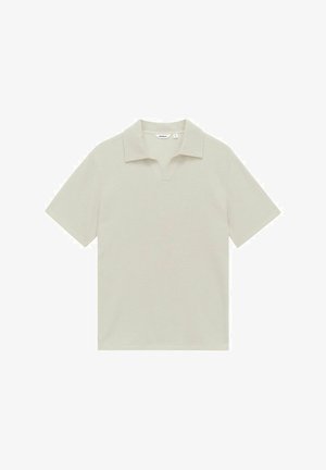 Lichtbeige polo shirt van een textuurstof, met korte mouwen en een ingesneden kraag. Etiket zichtbaar bij de halslijn.