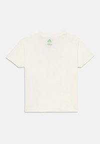 Camiseta blanca de manga corta con un logo verde de Adidas encima de "Disney" en la parte posterior del cuello, sobre un fondo blanco.