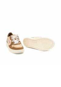 Brune ruskind og beige lædersneakers med hvide snørebånd, der har runde såler og mønstret tekstur på ydersålen. Logo på siden.