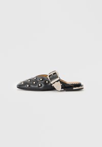 Black leather mule with rounded toe, textured surface featuring silver studs, and a decorative silver buckle detail on the strap.