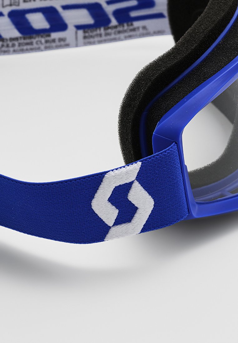 Blaue Schwimmbrille mit einem Schaumdichtungsring und einem breiten blauen Band mit einem weißen Logo. Die Gläser sind klar, umrahmt von einem soliden blauen Design.