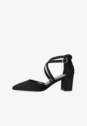 Décolleté in suede nero con punta a punta, caratterizzata da cinturini incrociati alla caviglia e tacco a blocco. Texture liscia e dettaglio con fibbia metallica.