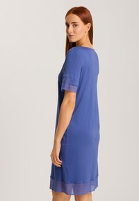 Vestito blu a maniche corte con una leggera forma ad A, tessuto morbido e dettaglio in pizzo testurizzato sull'orlo inferiore.