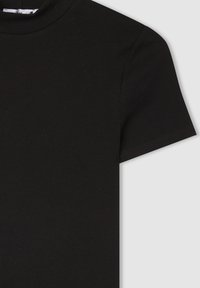 Czarna, prążkowana koszulka z krótkim rękawem i wysokim kołnierzem, o gładkiej fakturze i delikatnym rozciąganiu. Brak widocznych logo lub wzorów.