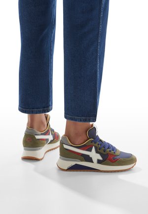 Sneaker multicolori caratterizzati da un mix di materiali, tra cui camoscio e rete, con un logo a stella bianco, accenti viola, oliva e rosso.