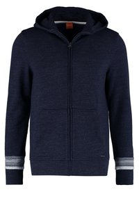 Marinblå zip-up hoodie i mjukt tyg, med dragsko i huvan, framfickor och randiga ärmslut. Hållbar konstruktion.