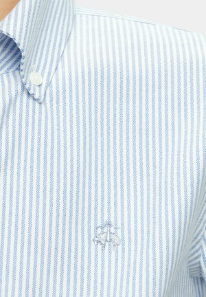 Blau-weiß gestreiftes Hemd mit Knöpfen, das einen klassischen Kragen und ein dezentes besticktes Logo auf der Brust aufweist. Stoff aus Baumwollmischung.