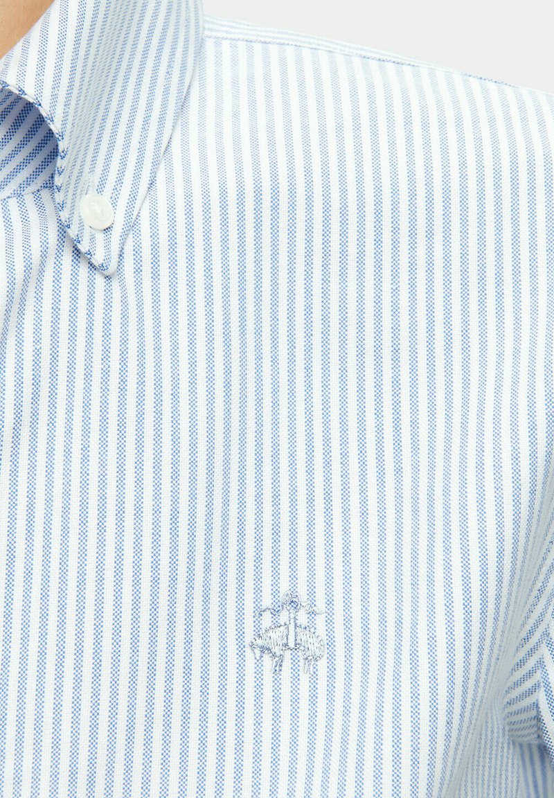 Blue and white striped button-up shirt featuring a classic collar and subtle embroidered logo on the chest. Cotton blend fabric.