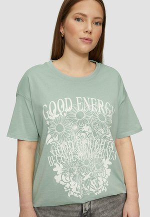 Mintgroene t-shirt met korte mouwen met een witte bloemenprint en de tekst "GOEDE ENERGIE GOEDE GEDACHTEN WORDEN GOEDE DINGEN" in een casual pasvorm.