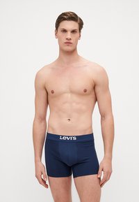 Boxeri din bumbac de culoare bleumarin, cu un tiv elastic branduit. Design ajustat, cu textură netedă și fără model vizibil.