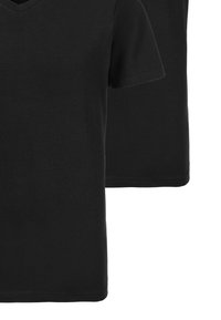 Czarne t-shirty z dekoltem w serek, wykonane z mieszanki bawełny, z krótkimi rękawami i luźnym krojem, ułożone jeden na drugim.