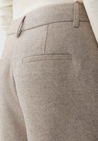 Grijze textuur broek met een dichte weving, voorzien van twee achterzakken en een nette tailleband. De stof heeft een subtiel patroon.