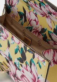 Blomstret håndtaske med en gul baggrund og mønstre af pink og blå blomster, tekstureret yderside, guldbelægning og en beige indvendig foring.