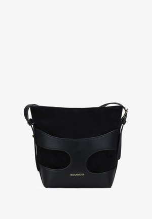 Bolso tipo bucket de cuero negro y ante con cortes laterales y un logo dorado. Correa ajustable, textura suave y forma estructurada.