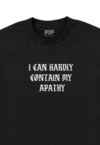 Camiseta de algodón negra con texto en estilo gótico en blanco que dice: "Casi no puedo contener mi apatía." Diseño clásico de cuello redondo.