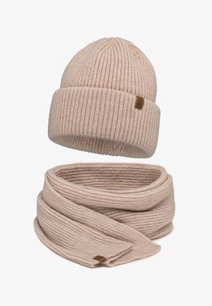 Beige gestreifte Strickmütze und passender Schal, beide mit kleinen braunen Markentags, auf einem weißen Hintergrund präsentiert.