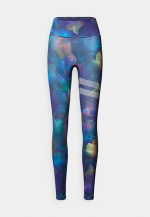 Tights med blomstermønster i nyanser av lilla, blått og grønt. Høyt liv, elastisk stoff, med tre vertikale reflekterende striper på leggen.
