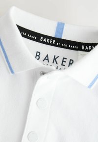 Biała koszulka polo z jasnoniebieskimi paskami na krawędziach kołnierza, białymi guzikami i czarną wewnętrzną metką z napisem "Baker by Ted Baker."