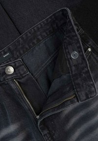 Czarne luźne dżinsy z denimu z zamkiem błyskawicznym, metalowym zapięciem na guzik oraz gładką fakturą, z metką na pasku.