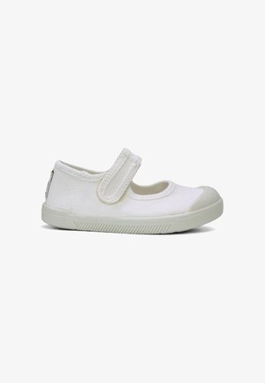 Chaussure Mary Jane en toile blanche avec semelle en caoutchouc et embout, dotée d'une bride unique réglable à scratch sur le cou-de-pied.