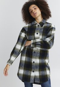 Green and navy plaid shirt jacket with a button-up front, folded collar, long sleeves, and pockets. Soft, wool-like texture.