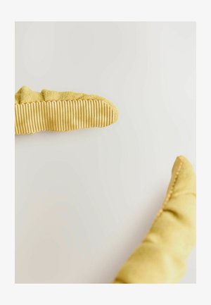 Zwei gelbe Wildlederhandschuhe mit gerippten Griffpolstern auf einer hellen Oberfläche, diagonal gegenüber voneinander positioniert.