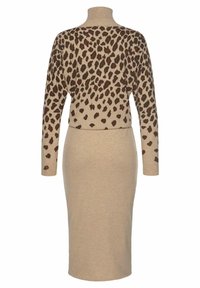 Leopardmönstrad, beige stickad tröja med långa ärmar och ståkrage, i kombination med en matchande figurnära pennkjol. Mjuk textur, sömlös design.