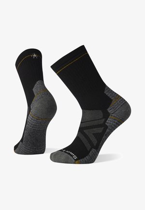 Calcetines en negro y gris con diseño texturizado, que cuentan con un talón y puntera reforzados, costuras de acento doradas y la marca Smartwool en la suela.