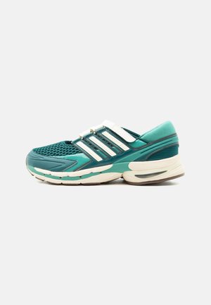 Baskets de sport vertes avec des bandes blanches, tige en mesh, et semelle blanche et turquoise amortie, vues de côté extérieur.