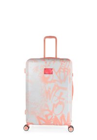 Maleta rígida blanca con grafiti rosa, con asa rosa, ruedas y placa con logotipo. Textura suave y forma rectangular.