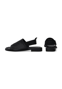 Schwarze Sandalen aus glattem Material mit offenem Zehenbereich, elastischem Riemen hinten und flacher Sohle. Sie zeichnen sich durch ein minimalistisches Design ohne sichtbare Beschläge aus.