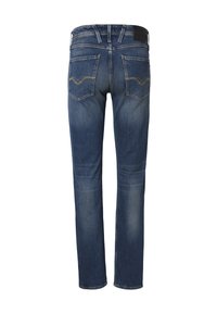 Jean en denim bleu vu de dos avec deux poches arrière et une légère décoloration sur les cuisses et les genoux.