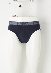 Slip da uomo color blu navy in cotone, con una cintura elastica grigia decorata con grafica nera del logo e un design che assicura una vestibilità comoda.