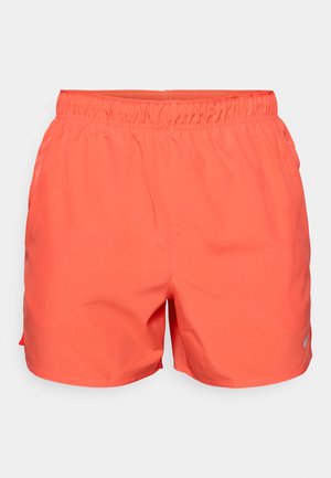 Shorts de sport corail avec une taille élastique, en matériau léger, et un petit logo réfléchissant en bas à gauche.