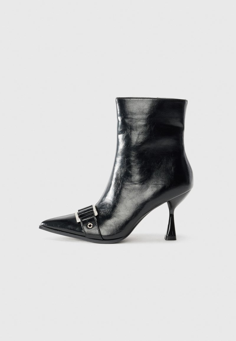 Stivale ankle nero in pelle lucida con punta affusolata, dotato di un dettaglio in fibbia argentata e un design unico del tacco triangolare.