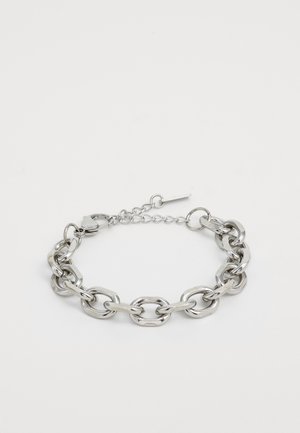 Bracelet en chaîne argentée avec de grands maillons ovales et un fermoir à mousqueton sur fond blanc, conçu pour un ajustement ajustable au poignet.