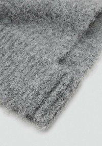 Gray knitted fabric with a soft, textured surface. Features a loose, fuzzy design and ribbed edges, emphasizing warmth and comfort.