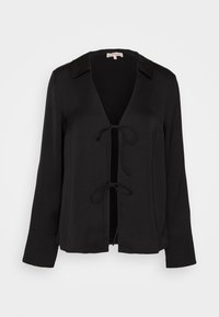 Blouse noire à manches longues avec un décolleté en V et une fermeture par nœud. Fabriquée en tissu doux, elle présente un col et un design décontracté.