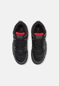 Zapatillas negras con acentos rojos, con parte superior de malla, suela de goma y punteras reforzadas. Diseño de cordones con logo en la lengüeta.