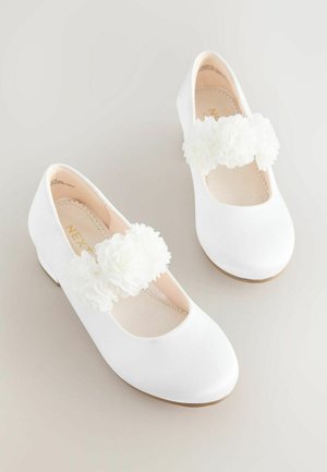 Ballerine in raso bianco con punta arrotondata, caratterizzate da dettagli floreali bianchi sulla cinghia e una fodera interna texturizzata. Tacco basso.