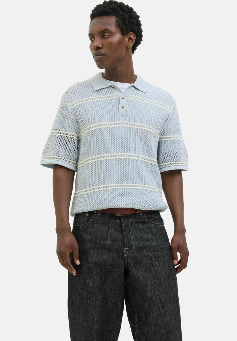 Lyseblå strikket polo med korte ærmer, prydet med stribede mønstre og en tre-knaps lukning, parret med mørk denim jeans.