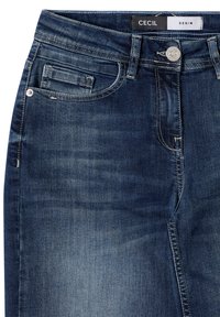 Jeans de mezclilla azul oscuro con un corte clásico, cinco bolsillos y costuras visibles. Cuentan con un cierre de botón y una etiqueta del logo en la cinturilla.