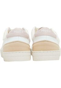 Sneakers bianchi con un accento rosa chiaro sul tallone, caratterizzati da una texture liscia, suola in gomma piatta e il marchio "MoEa" sulla parte posteriore.