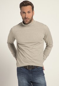 Ljusgrå tunn tröja i mjukt material med långa ärmar, tillsammans med blå denimjeans och ett mörkt bälte. Minimalistisk design, utan mönster.