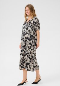 Leopard print dress with short puff sleeves, mid-calf length, lightweight fabric in neutral tones, paired with black slingback heels.