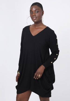 Robe noire avec un décolleté en V, des manches longues ornées de boutons dorés et des poches latérales. Tissu doux avec une coupe décontractée et un design drapé.