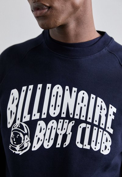 Sweatshirt marine avec un texte blanc audacieux "Billionaire Boys Club" et un graphique d'astronaute. Fabriqué en tissu doux avec un design à col rond.