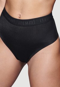 Schwarze, hochtaillierte Unterhose mit glatter Textur. Verfügt über einen breiten, geprägten Bund mit der Aufschrift "ITEM m6." Einfaches und elegantes Design.