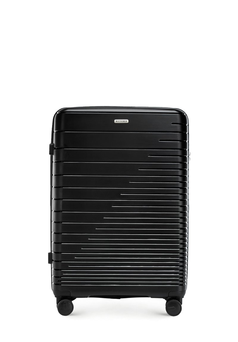 Maleta rígida negra con surcos paralelos, dos ruedas, asa superior y placa de marca. Textura suave y forma rectangular.